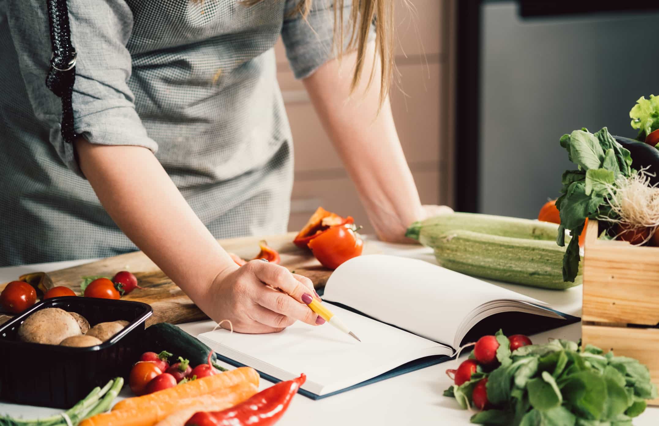 Woman Looking over Plant-Based Cookbooks